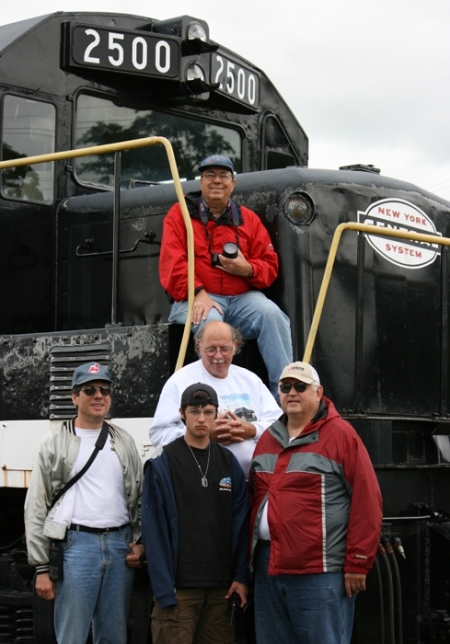 Akron Railroad Club members gathered on the New York Central diesel locomotive at the Lake Shore Railway Museum in North East, Pennsylvania, on August 30 during the overnight outing. In the front row are (L-R) Marty Surdyk, Richard Thompson and Rick Houck. Behind Rich is Tim Krogg and sitting on the locomotive is Craig Sanders.